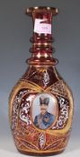 A vintage 20th Century Cranberry glass Bohemian style decanter decorated with three panels of a