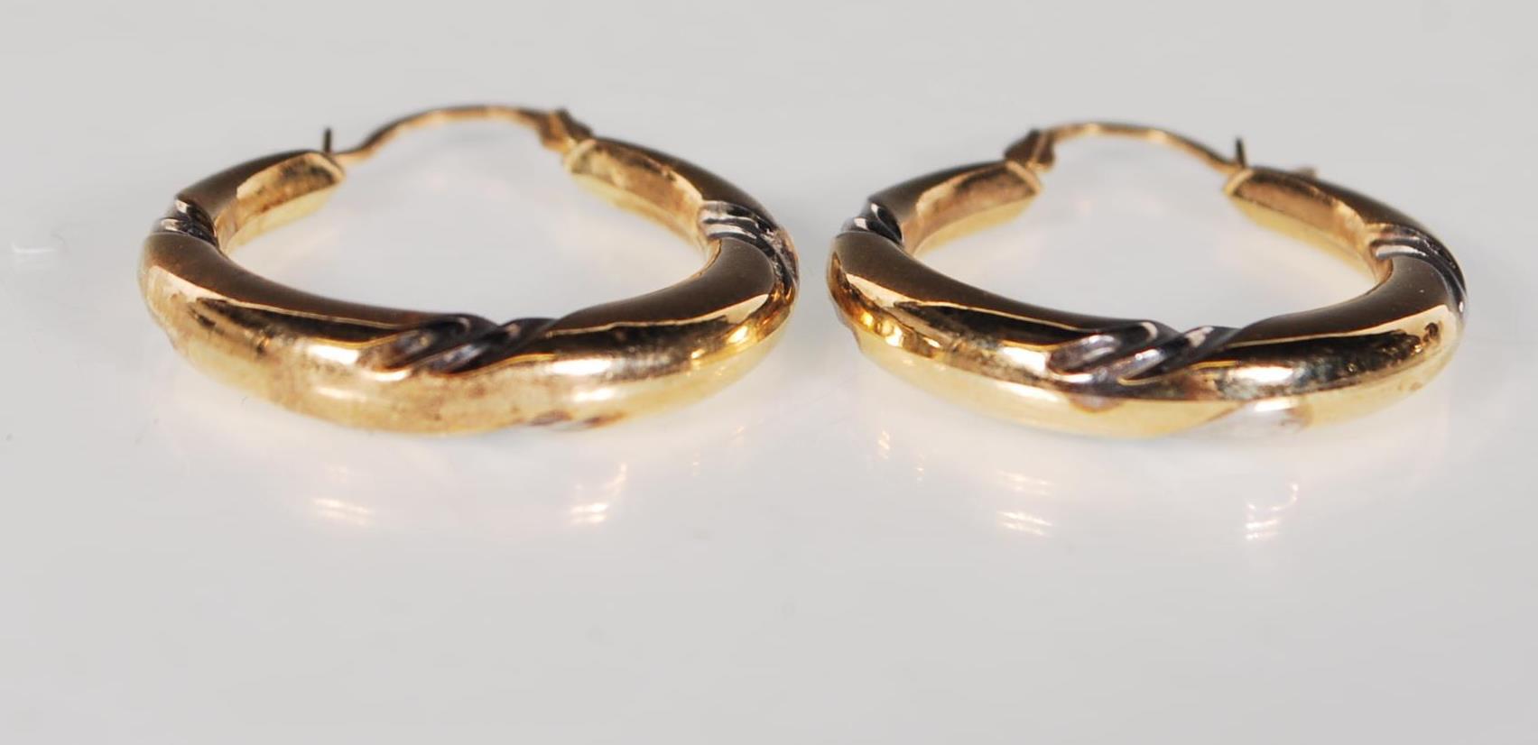 A pair of 9ct yellow and white gold hoop earrings. Stamped 375. Weighs 1g. - Image 2 of 2