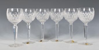 A set of six Waterford crystal cut wine glasses, the cut class bowls raised on faceted cut stems