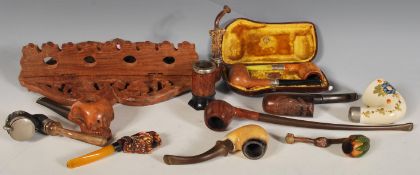 A selection of vintage 20th Century smoking pipes to include a meerschaum pipe carved holding