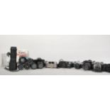 A collection of vintage 20th Century 35mm cameras and lenses to include a Cannon EOS 10, Cannon A-