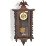 A 20th Century wooden cased Vienna regulator pendulum wall clock having glazed panels with a round