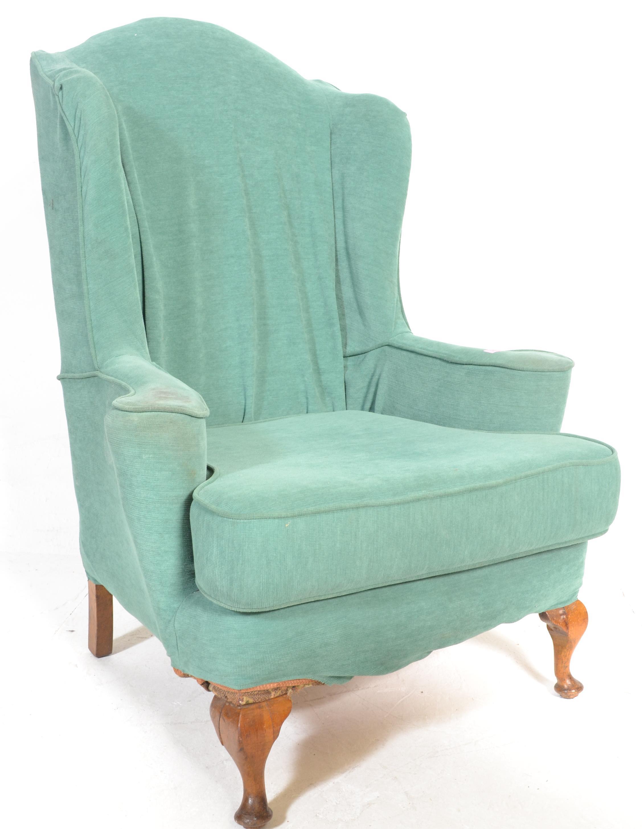 A 20th century antique style large Georgian revival wing back armchair...