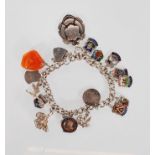 An English hallmarked charm bracelet having a curb ink bracelet with a heart lock with 16 charms