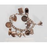 An English hallmarked silver charm bracelet having a faceted cub link chain with eleven charms to