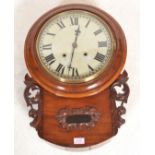 An early 20th Century mahogany cased station wall clock having a round enamelled face with roman