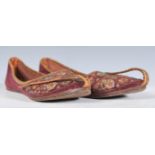 A pair of early 20th Century Persian leather slippers having embroidered decoration stitched with