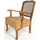 An early 20th Century walnut framed bergere chair / armchair having a cane worked back support