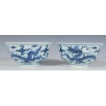 A pair of 20th Century Chinese blue and white bowls having round footed bases and flared rims having