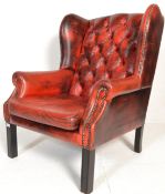 A 19th Century Victorian red leather oxblood Chesterfield wing back armchair raised on straight