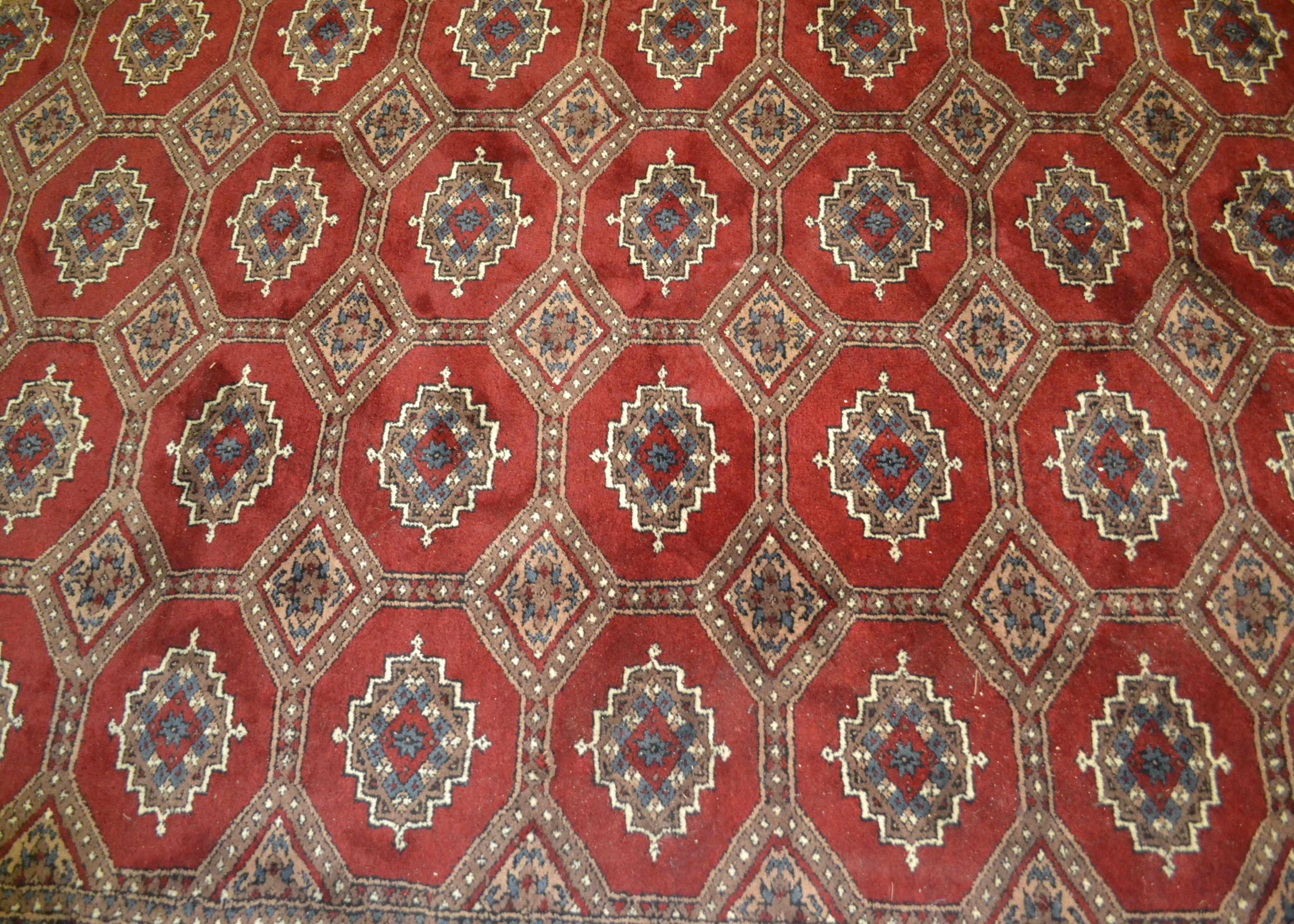 A 20th Century hand knotted floor rug carpet of large proportions in a Bukhara design having a red - Image 2 of 6