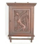 A 1920's mahogany hanging spice cupboard. The central panel door with phoenix carving having inset
