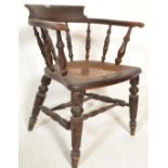 A Victorian 19th century mahogany framed smokers bow armchair. Raised on turned legs united by