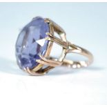 A stamped 9ct gold ladies dress ring set with a large round faceted purple stone. Weight 11.5g. Size