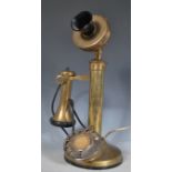 A vintage 20th Century ring dial stick telephone having a brass earpiece with bakelite mouth piece