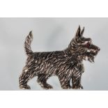 A sterling silver brooch in the form of a Scottie dog set with a ruby eye. Stamped sterling to