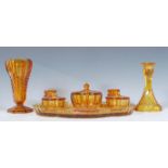 An early 20th Century Art Deco pressed amber glass dressing table set having geometric decoration