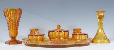 An early 20th Century Art Deco pressed amber glass dressing table set having geometric decoration
