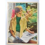 A vintage 20th Century shop display advertising showcard for Kodak cameras depicting a lady seated