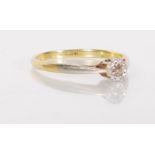 A stamped 18ct gold and platinum solitaire ring set with a round cut white stone with a faceted