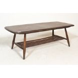 A retro 20th Century Ercol dark beech and elm coffee table raised on tapering supports united with