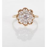 An English hallmarked 9ct yellow gold ring having a decorative flower head mount set with a