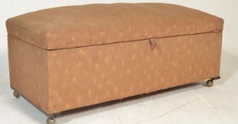 An early 20th Century floral fabric covered ottoman having a spring top to the hinged lid. The lid