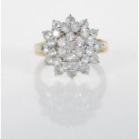 An English hallamarked 9ct gold cluster ring set with a cluster of white stones to the head.