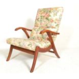 A mid century retro armchair being raised on angular legs with floral upholstered chintz pattern