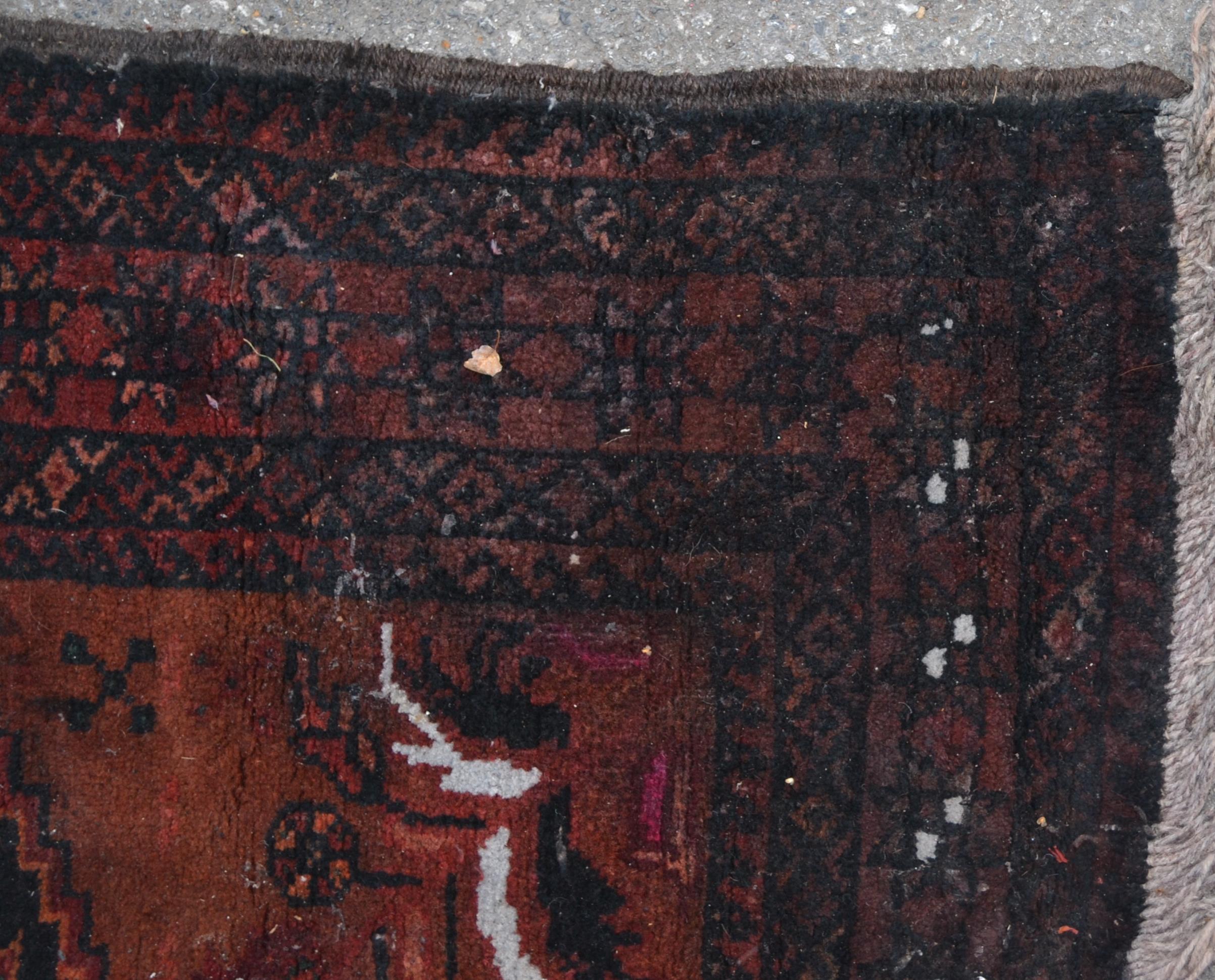 A 20th century dark red and blue ground Persian / Islamic Bokhara rug having a central panel of - Image 3 of 4