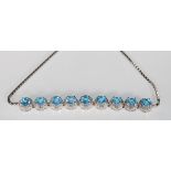 A stunning silver line bracelet set with nine blue topaz stones with each having a halo of CZ's on a