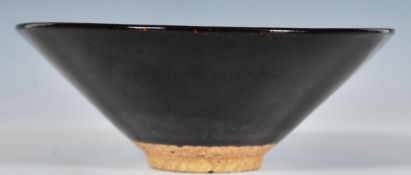 A Chinese Chawan stoneware tea bowl having straight tapering sides, glazed with a mottled deep brown