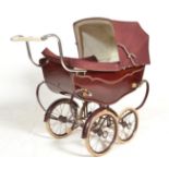 A vintage retro 20th Century Silver Cross children's dolls pram finished in dark red. The hooded