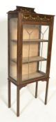 An early 20th Century Edwardian mahogany vitrine display cabinet being raised on square tapering