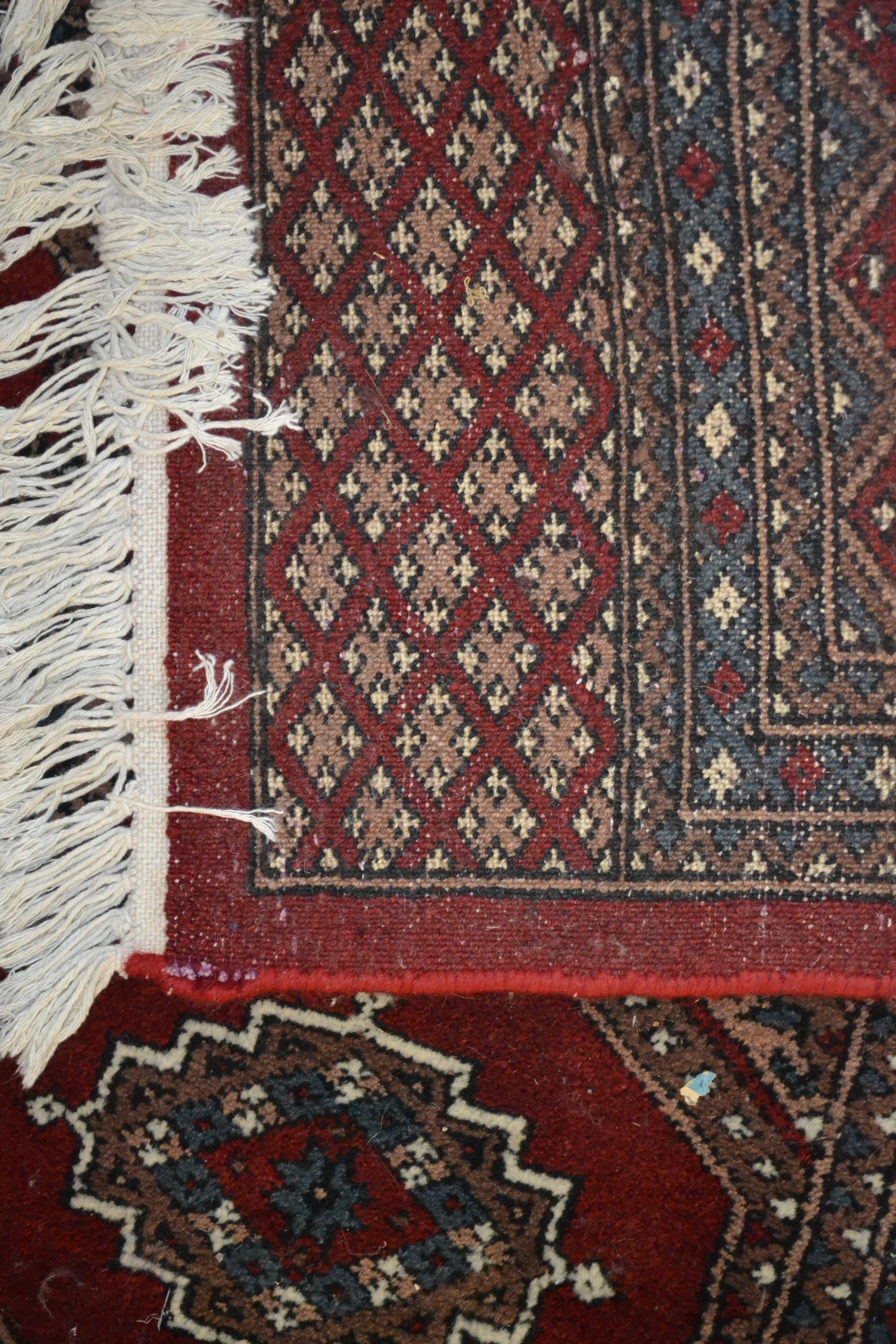 A 20th Century hand knotted floor rug carpet of large proportions in a Bukhara design having a red - Image 6 of 6