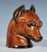A 19th Century hunting interest ceramic stirrup cup in the form of a fox with stylised novelty