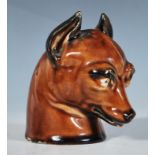 A 19th Century hunting interest ceramic stirrup cup in the form of a fox with stylised novelty