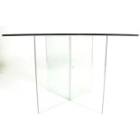 A vintage retro 20th century modernist glass dining table having a square table top with central