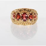 An English hallmarked 9ct yellow gold ring set with five graduating faceted cut red stones on a