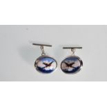 A pair of silver cufflinks of oval form having central enamel panels depicting spitfires amongst the