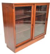 An early 20th Century mahogany display cabinet / shop fitting having twin glass fronted sliding