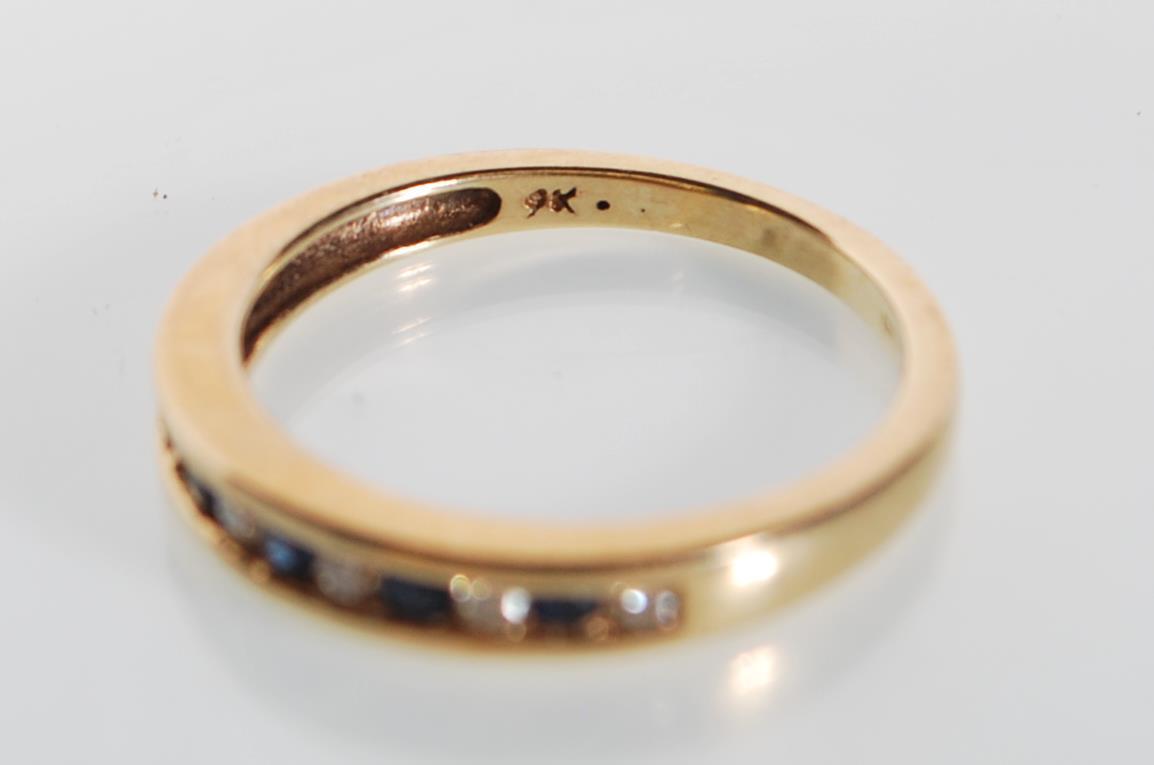 A stamped 9ct gold ring being channel set with alternate blue and white stones. Weight 2.3g. Size - Image 5 of 6