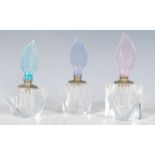 A group of three 20th Century Century faceted glass perfume bottles each having pastel coloured
