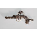 An unusual silver pendant whistle in the form of a flintlock pistol having finely engraved foliate