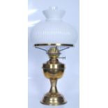 A large 20th Century brass oil lamp raised on a round plinth base with a bulbous reservoir to the