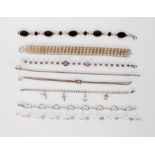 A selection of silver bracelets to include a white stone spacer bracelet, a black enamelled oval