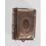 A vintage silver white metal vesta / sovereign case in the form of a book. The spring hinged front