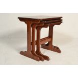A nest of three 20th Century Danish influenced teak wood occasional tables raised on twin supports