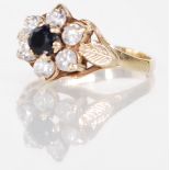 A 9ct gold hallmarked cluster ring having a central blue stone fitted to a prong mount set within