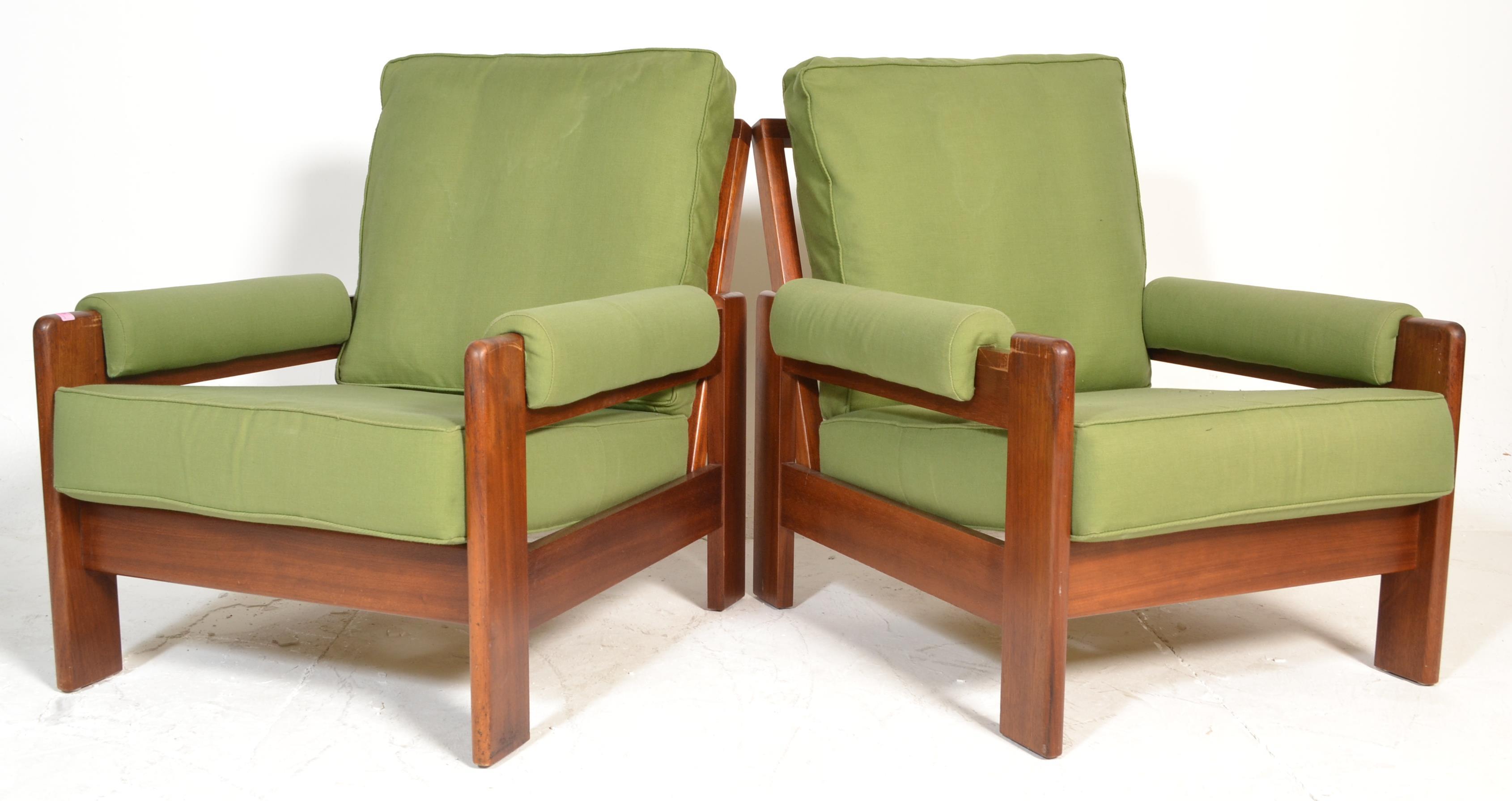 A pair of mid century teak wood easy armchair. Raised on teak show wood...